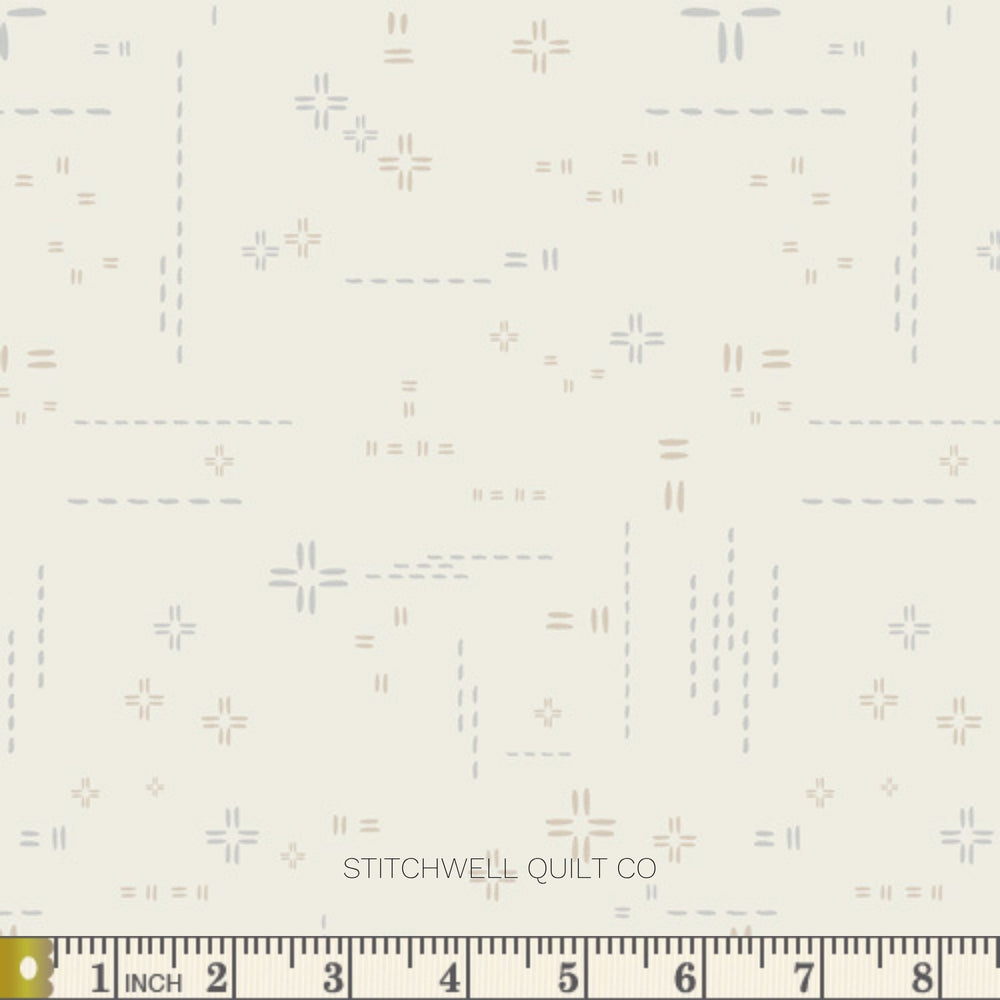 A close-up of fabric with a repeating geometric pattern of small crosses, dashes, and equals signs in muted blue, gray, and taupe on a warm off-white background. A ruler along the bottom edge shows measurements in inches.